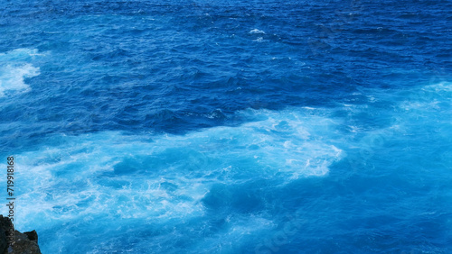 Turquoise ocean sea water white wave splashing deep blue sea. Bird eye view monster wave splash on rock. Tropical sea beach in summer seaside outdoor. Ocean island beautiful dramatic landscape.