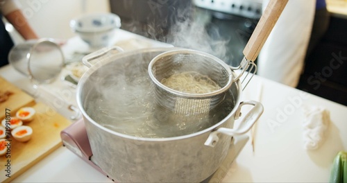 Cooking, kitchen and Japanese noodles in pot in boiling water for lunch, meal preparation and dinner. Food, cuisine and traditional dish, ingredients and steam for wellness, diet and nutrition