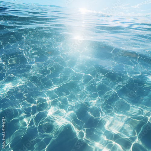 Blue sea water surface with sunbeams and lens flare effect.