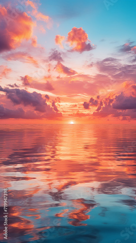 Beautiful pink sunset over the sea with clouds reflected in the water.