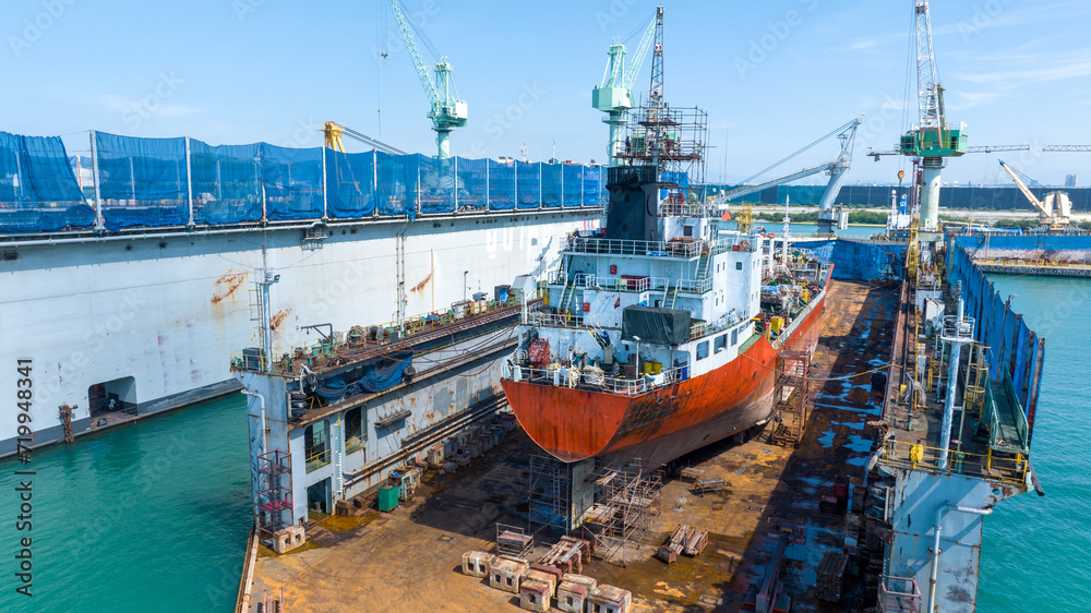 Naklejka premium Oil tanker ship at dry dock concept maintenance service. working at dry dock. Insurance and Maintenance Crude tanker Ship concept. Freight Forwarding Service maintenance Insurance.