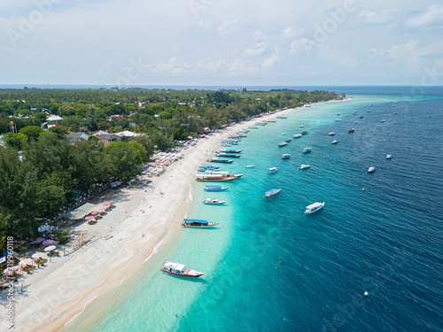 Drone photo of Indonesian island, Gili Trawangan and its beautiful crystal clear waters ideal for snorkeling and sailing typical boats. photo