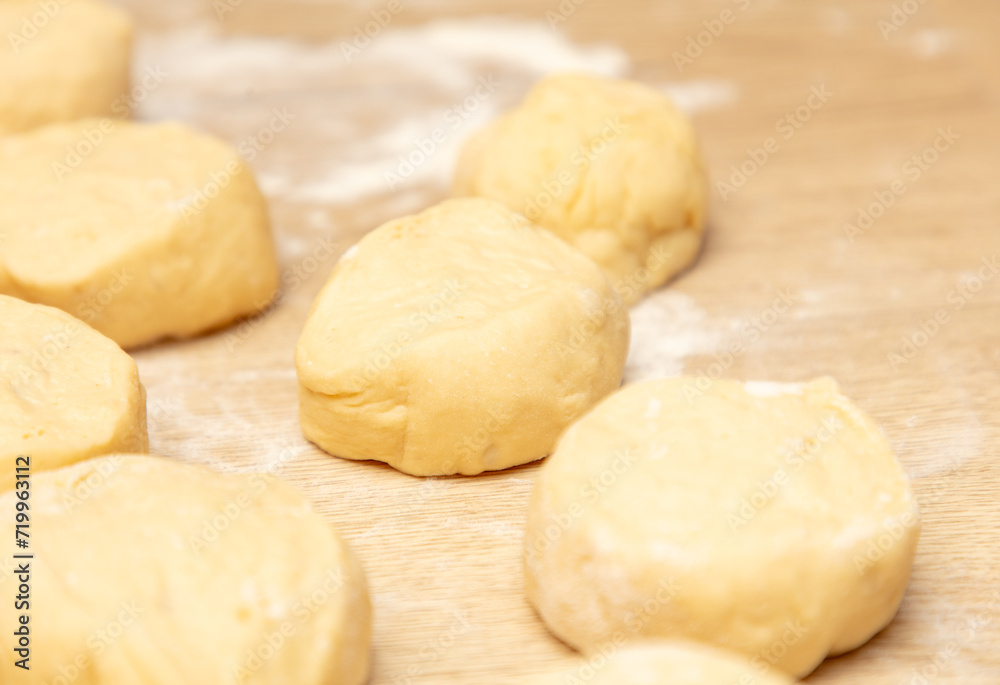 Pieces of dough on the table in flour.
