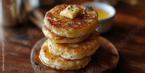 Potato pancakes with butter and herbs on a wooden cutting board.Cottage cheese pancakes with honey and butter on a wooden background.
