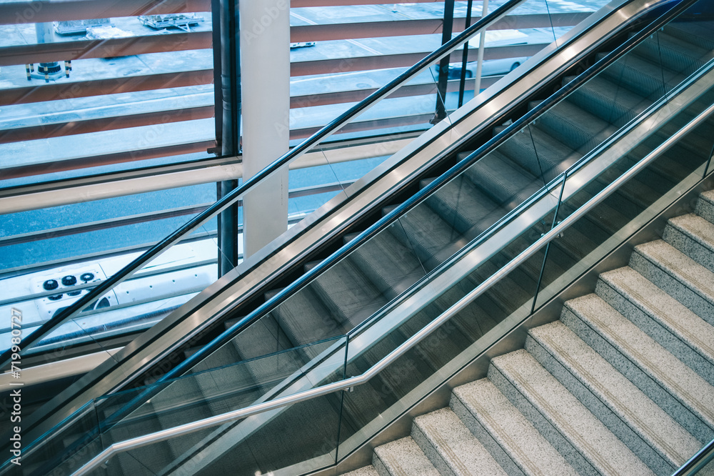 Fototapeta premium Modern escalator beside the stairway