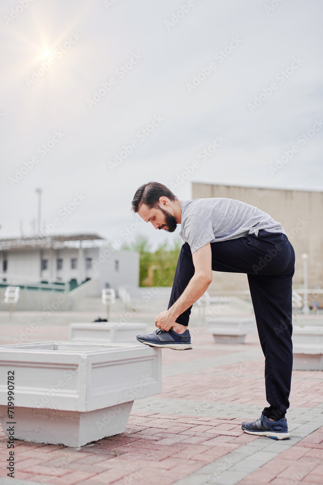 Jogger tying his shoelaces before training Jogger tying his shoelaces before training