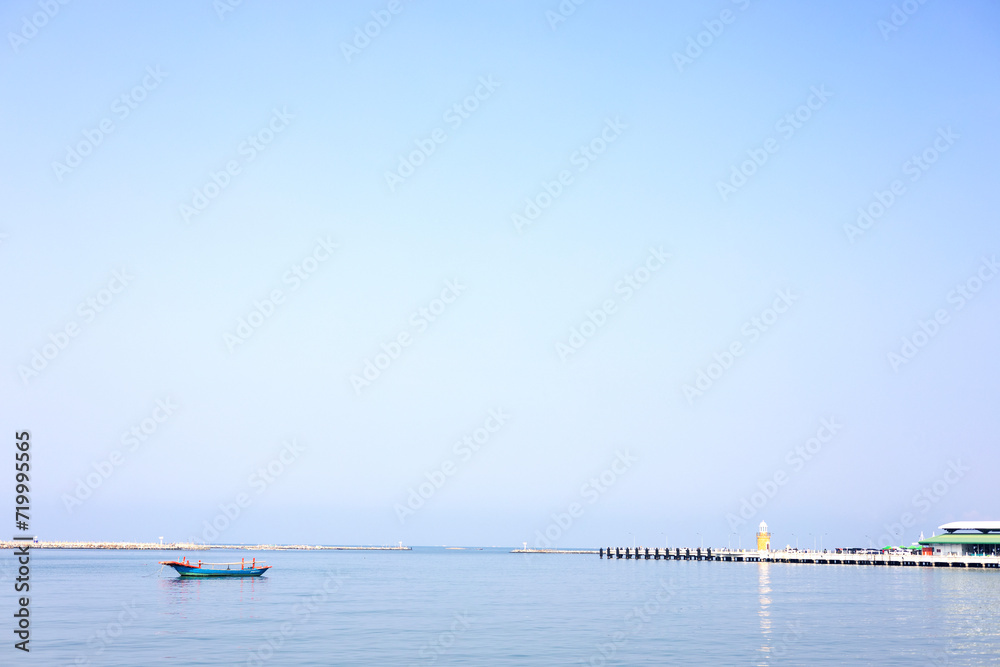 Lighthouse And Fishing Boat Over The Calm Sea