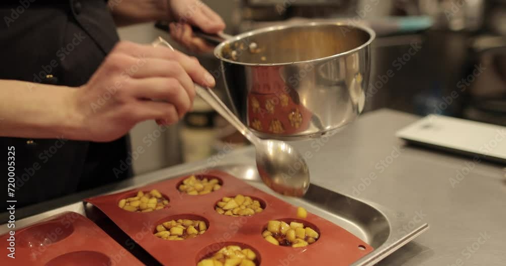 Preparation of apple desserts in a silicone baking tray. Filling a silicone tray with diced apples during the work of a professional confectioner. Preparation of apple desserts in a silicone baking tray. Filling a silicone tray with diced apples during the work of a professional confectioner.