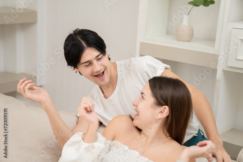 A young man putting around his Surprise gift girlfriend's Valentine's Day concept. Lovers at home celebrating Valentine's Day.