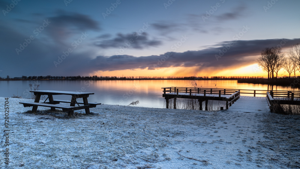 Jetty and wooden picnic table by Lake Dirkshorn in a winter setting. Jetty and wooden picnic table by Lake Dirkshorn in a winter setting.