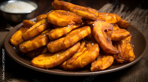 Homemade fried caramelized bananas with cinnamon and sugar crystals in a beautiful bowl on the table. Close-up