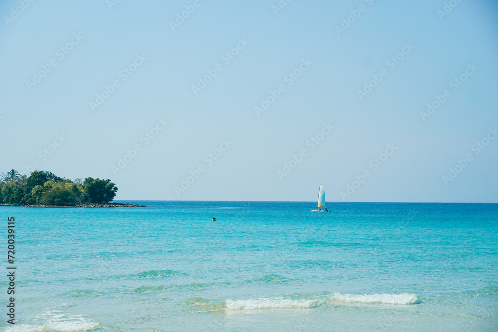 Fototapeta premium Tropical beach at Koh Kood, Thailand. turquoise sea water, ocean wave, yellow sand, green palms, sun blue sky, white clouds, beautiful seascape, summer holidays, exotic island vacation.