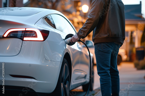 Man Charging an Electric Car Battery Concept © Arcane Imaginarium