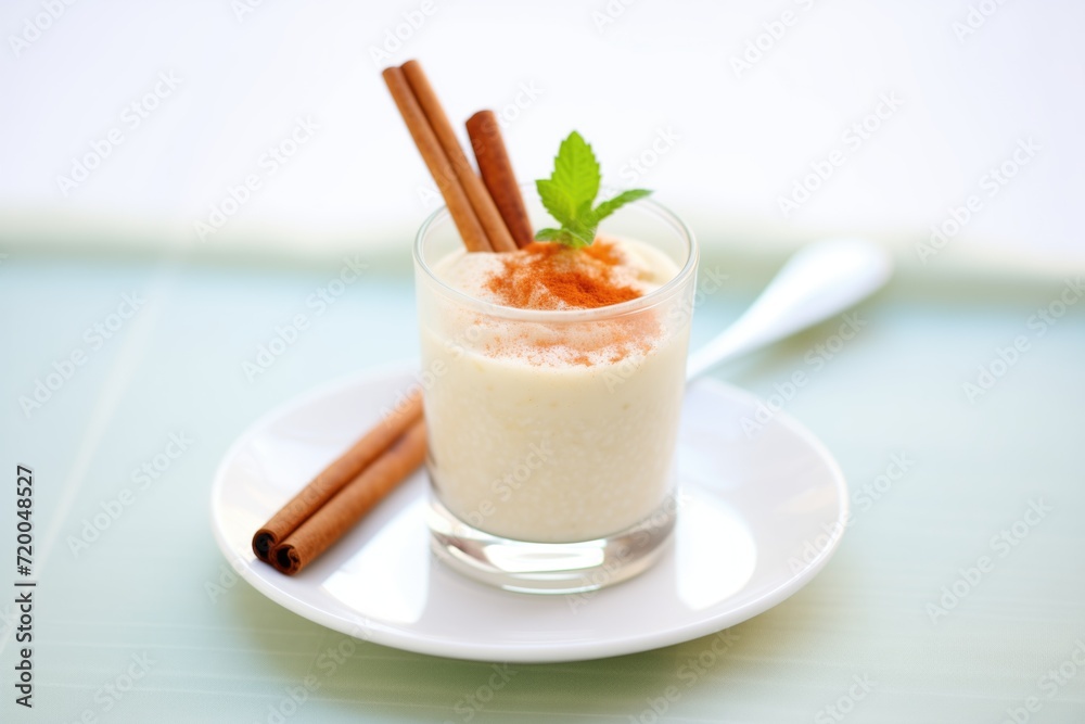 glass filled with creamy rice pudding drink, cinnamon stick garnish glass filled with creamy rice pudding drink, cinnamon stick garnish