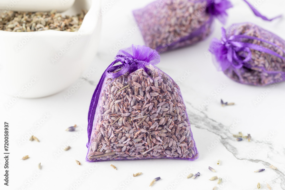Purple sachet with dried lavender flowers on marble background. Purple sachet with dried lavender flowers on marble background.