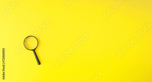 Magnifying glass, magnifying glass in a black frame on a yellow background.  Concept research, objects magnification.  Flat top view.  Space for copying text.