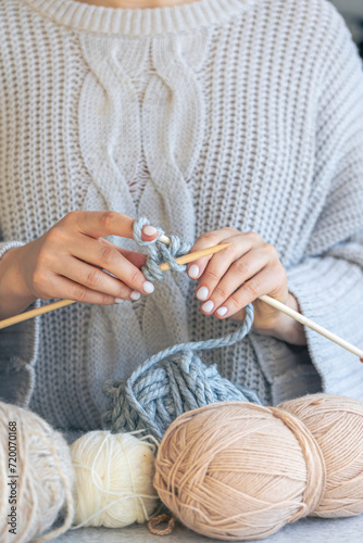 Close-up of hands knitting using circular needles.