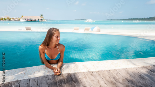 Travel vacation - Beautiful young pretty blonde girl back in bikini on her perfect sport sexy body relax in pool near paradise beach at tropical caribbean maldives beach at sunny day in hotel