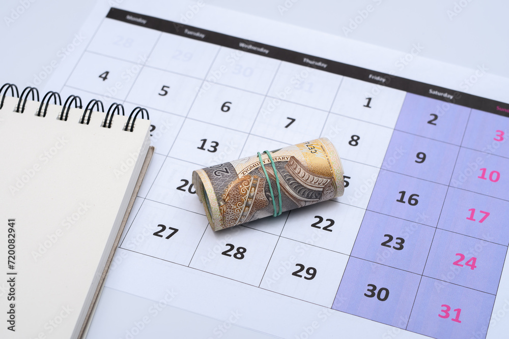 Polskie pieniądze leżą na kartce z kalendarza , planować wydatki  - obrazy, fototapety, plakaty 