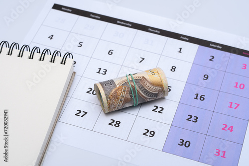 Polskie pieniądze leżą na kartce z kalendarza , planować wydatki 