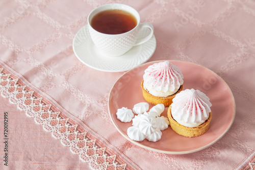 white and pink cupcakes  and cup of tea on vintage tablecloth