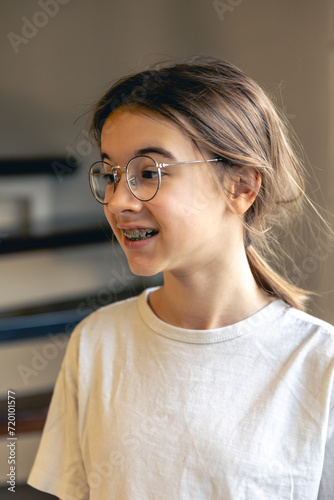 Portrait of a teenage girl with glasses and braces.