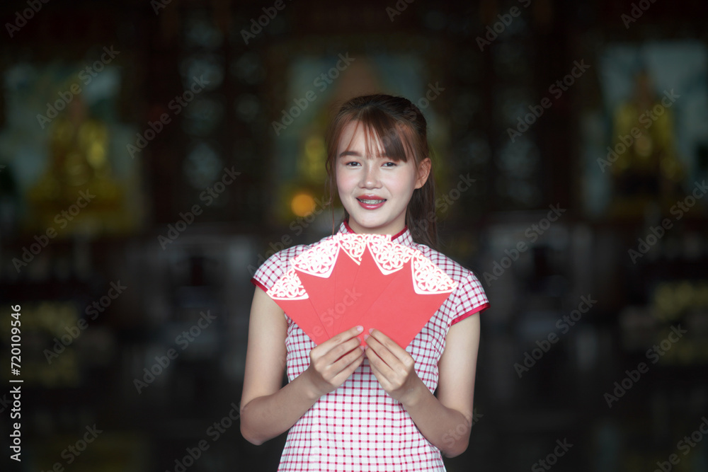 A young Asian girl holding a red envelope of Ang Pao for Chinese New Year