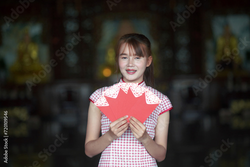Obraz na płótnie A young Asian girl holding a red envelope of Ang Pao for Chinese New Year w salonie