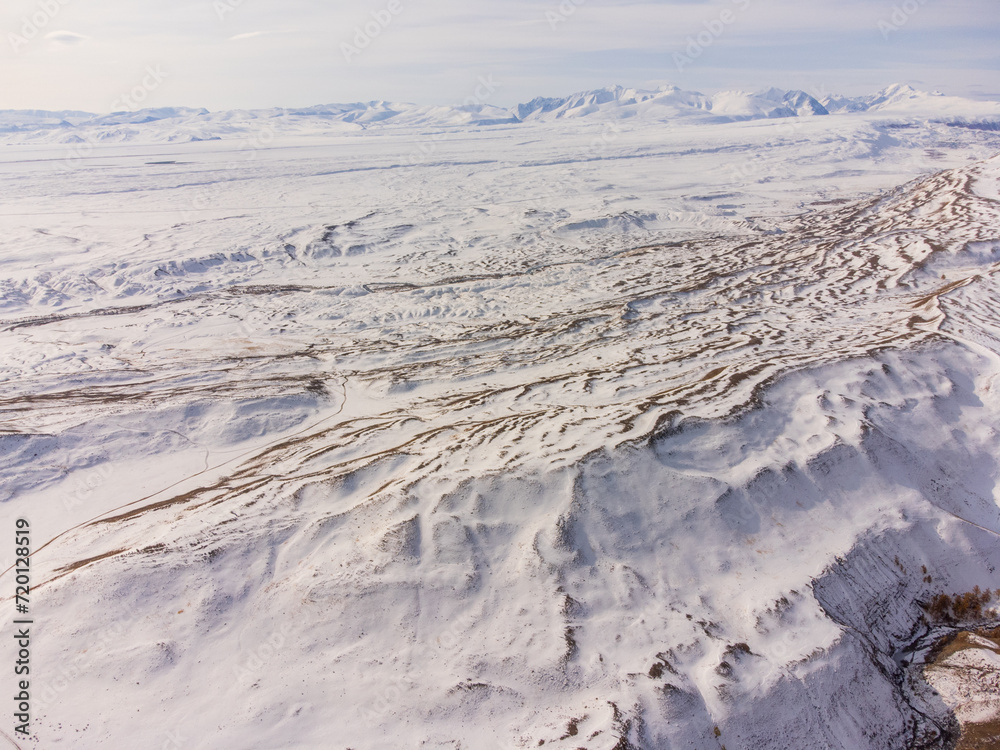 Stunning aerial shot capturing the vast, snow-blanketed landscape of the Altai Mountains in the Russian winter. Stunning aerial shot capturing the vast, snow-blanketed landscape of the Altai Mountains in the Russian winter.