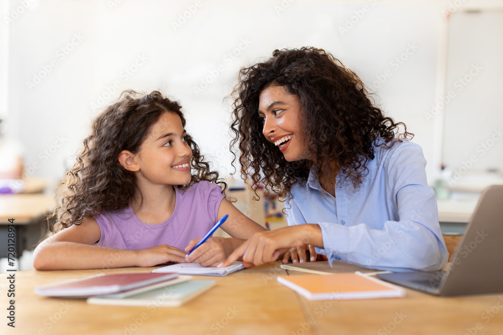 Mother helping daughter to do lessons, tutor is engaged with child, teaching to write and count, school lessons with teacher Mother helping daughter to do lessons, tutor is engaged with child, teaching to write and count, school lessons with teacher