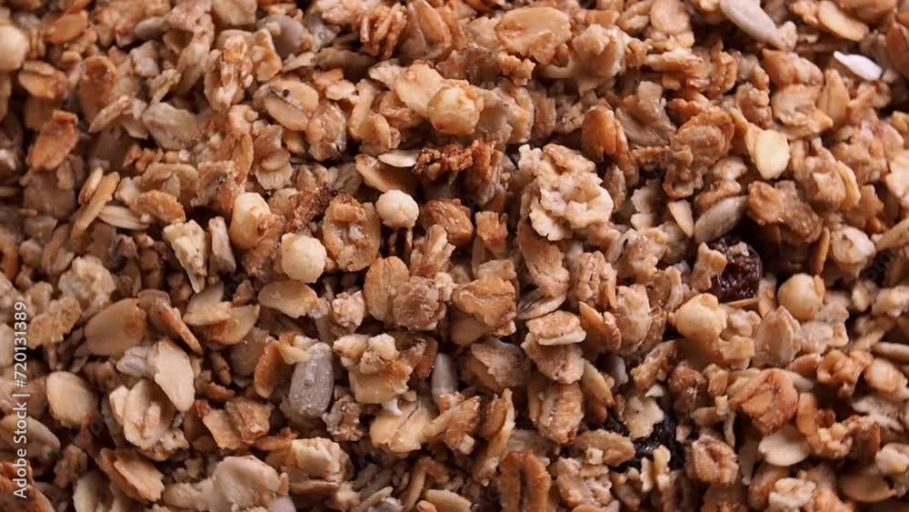Background muesli oat flakes nuts and raisins, rotation. The concept of healthy eating, crispy granules. close up Background muesli oat flakes nuts and raisins, rotation. The concept of healthy eating, crispy granules. close up