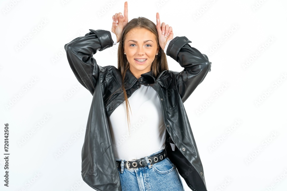 Funny Young beautiful woman shows horns, fingers on head gesture, posing silly and cute Funny Young beautiful woman shows horns, fingers on head gesture, posing silly and cute