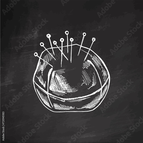 Hand-drawn sketch of pincushion with needles and pins on chalkboard background. Handmade, sewing equipment concept in vintage doodle style. Engraving style.