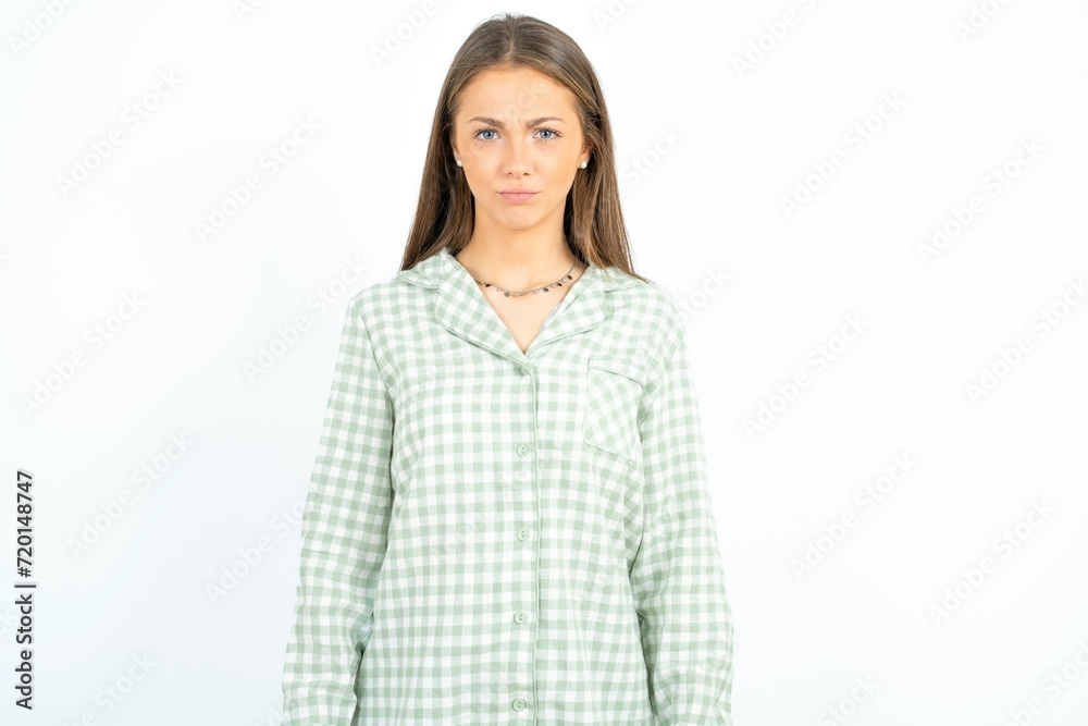 Offended dissatisfied Beautiful young woman wearing green plaid pyjama with moody displeased expression at camera being disappointed by something Offended dissatisfied Beautiful young woman wearing green plaid pyjama with moody displeased expression at camera being disappointed by something