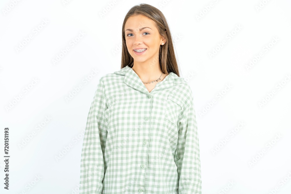 Young beautiful woman wearing green plaid pyjama with nice beaming smile pleased expression. Positive emotions concept Young beautiful woman wearing green plaid pyjama with nice beaming smile pleased expression. Positive emotions concept