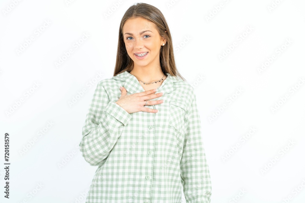 young beautiful woman wearing green plaid pyjama smiles toothily cannot believe eyes expresses good emotions and surprisement young beautiful woman wearing green plaid pyjama smiles toothily cannot believe eyes expresses good emotions and surprisement