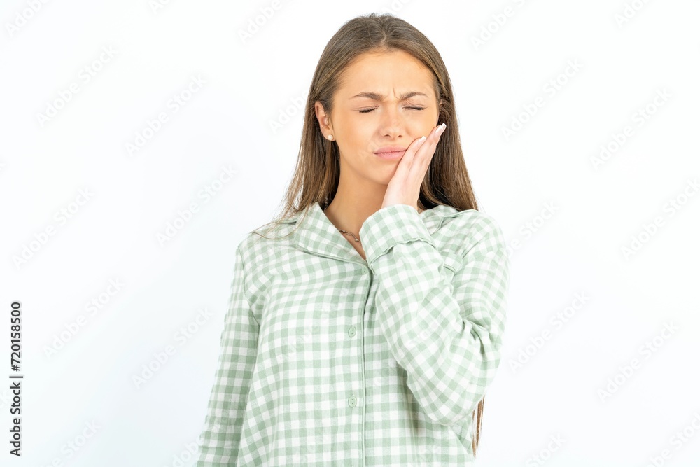 young beautiful woman wearing green plaid pyjama, with toothache young beautiful woman wearing green plaid pyjama, with toothache