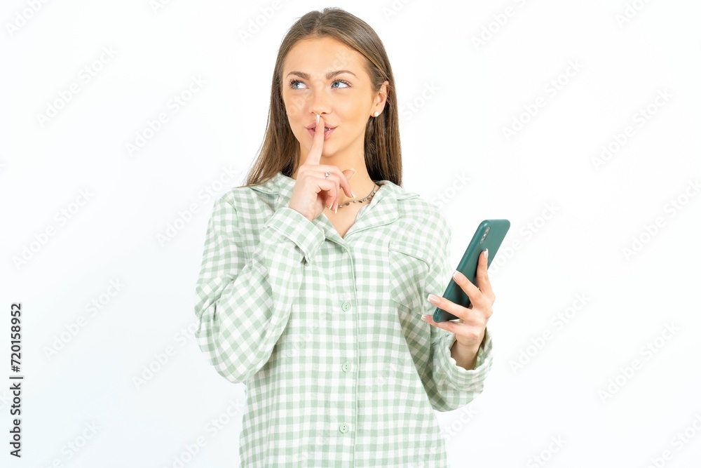 young beautiful woman wearing green plaid pyjama, holding modern gadget ask not tell secrets young beautiful woman wearing green plaid pyjama, holding modern gadget ask not tell secrets