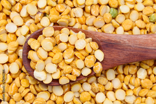 Split chickpeas or chana dal in a wooden spoon close-up view 