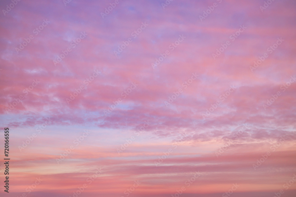 Beautiful sky tinted by the sun leaving vibrant shades of gold, pink, blue and multicolored. Clouds in the twilight evening and morning sky. Cloudy sky background in the evening and during the day.
