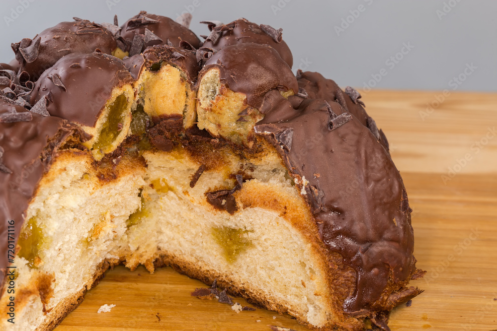 Partly cut chocolate panettone with profiteroles, fragment close-up Partly cut chocolate panettone with profiteroles, fragment close-up