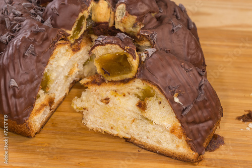 Partly cut chocolate panettone with profiteroles, fragment close-up