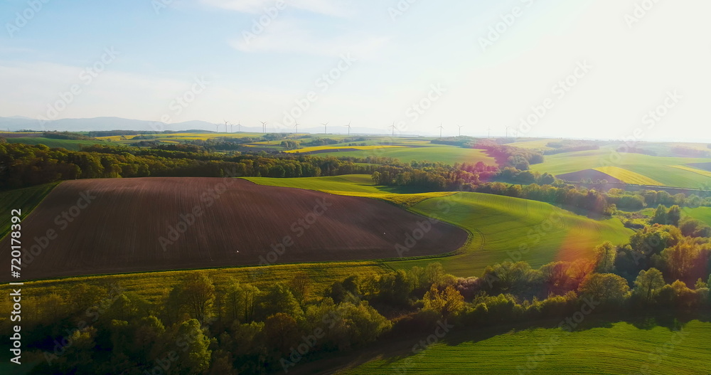 Beautiful agricultural landscape against ecological windmills farm