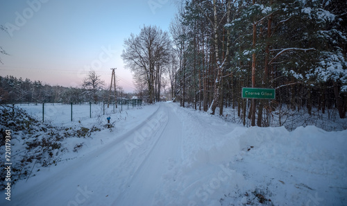 Iście zimowe , śnierzne krajobrazy. Tablica z nazwą (Czarna Glina )miejscowości w lesie droga poprzez śnieg.