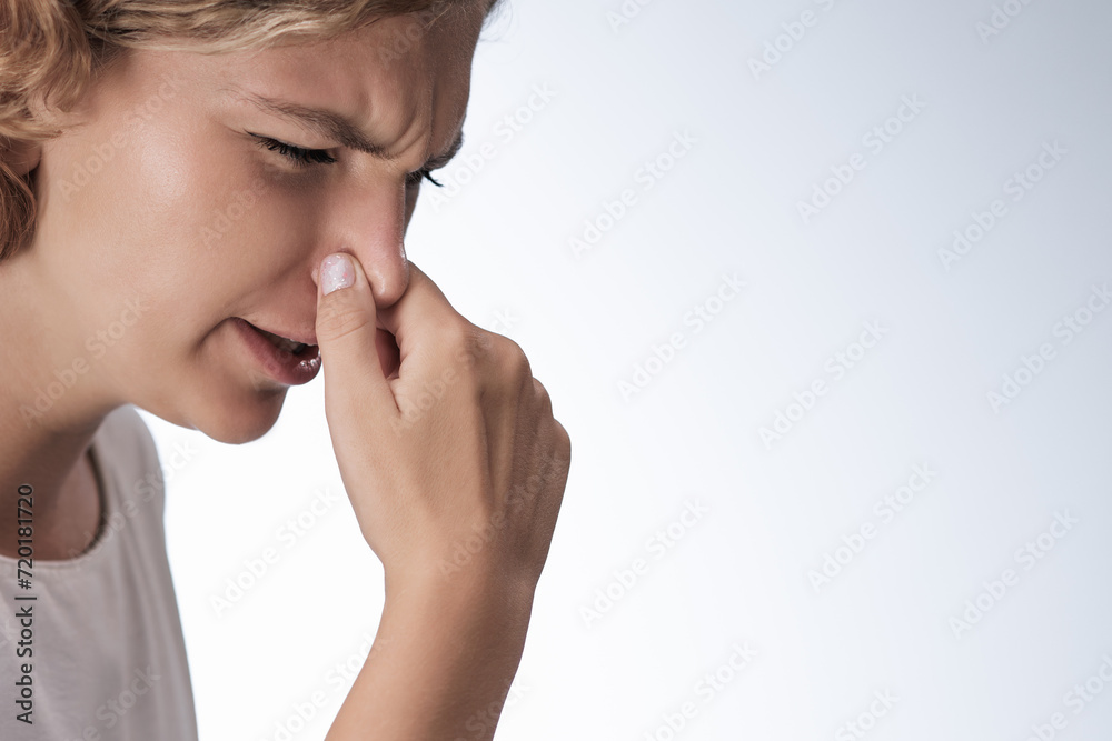 Strong disgust smell bad breath of young woman. Close-up portrait of a girl covering close her nose by fingers, expression face disgusting, dislike odor Strong disgust smell bad breath of young woman. Close-up portrait of a girl covering close her nose by fingers, expression face disgusting, dislike odor