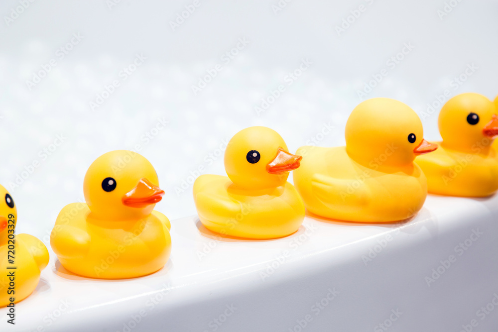 yellow rubber duck on top of a white bathtub
