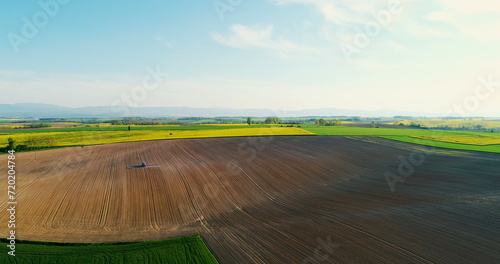 Aerial shoot of tractor working on field. AGRICULTURE.