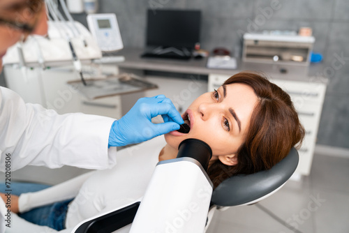 The dentist is examining the patient s teeth.