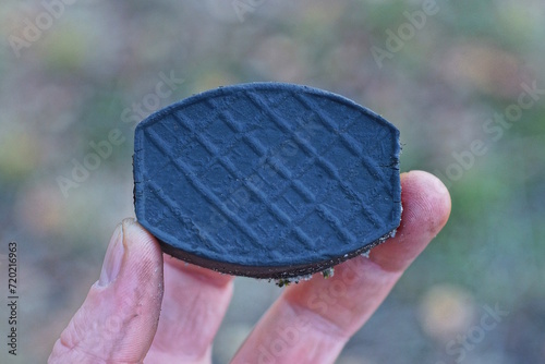 Fototapeta Naklejka Na Ścianę i Meble -  fingers holding one small black plastic pedal on the street