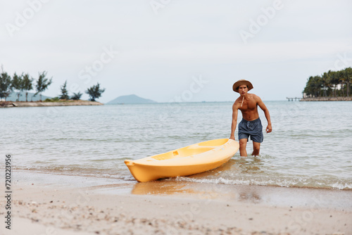 Happy Asian Man Kayaking on a Tropical Beach: Summer Vacation Fun